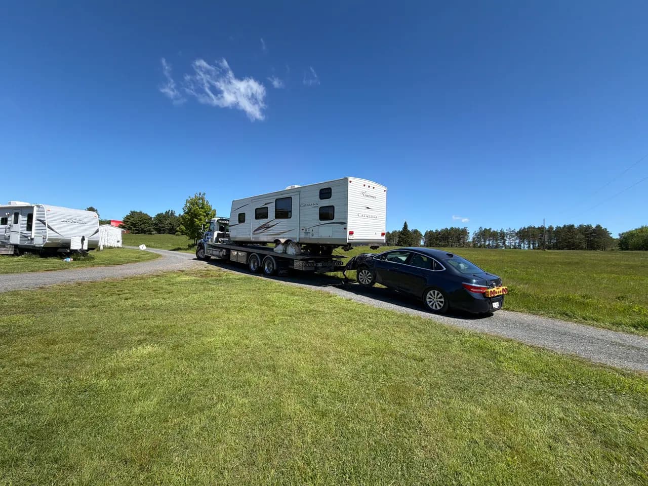 Dynamic Towing truck hauling an RV travel trailer with a car in tow