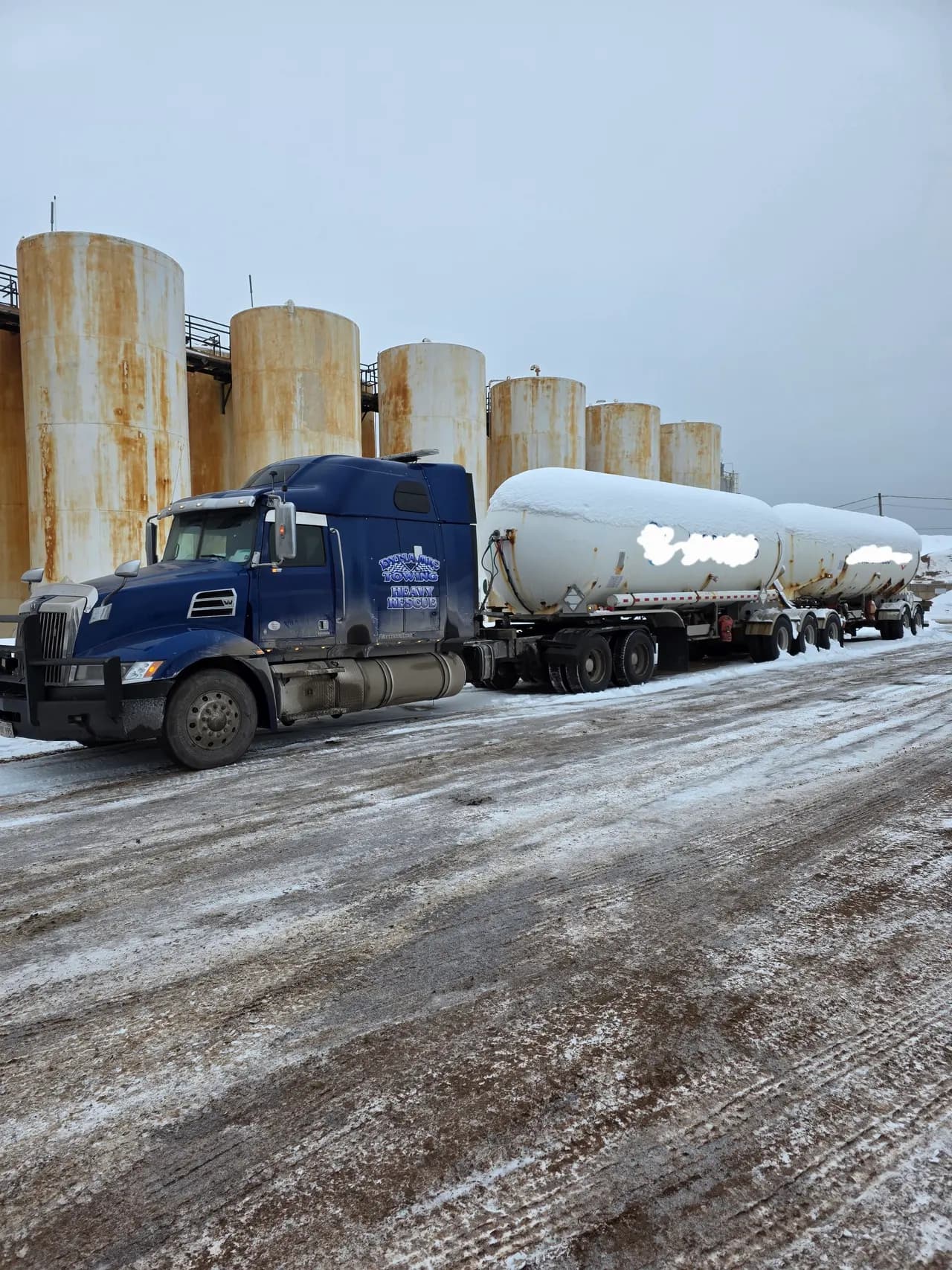 Dynamic Towing heavy-rescue wrecker towing a propane tanker in a snowy yard