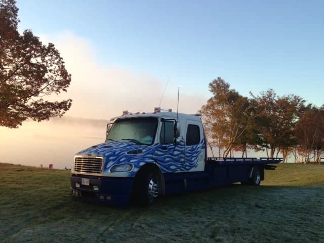 Dynamic Towing flat-deck wrecker at a New Brunswick lakeside, golden-hour fog