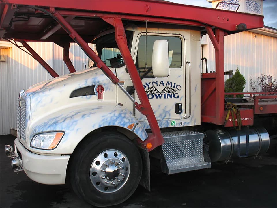 Dynamic Towing Kenworth flat-deck unit, front-quarter view showing logo
