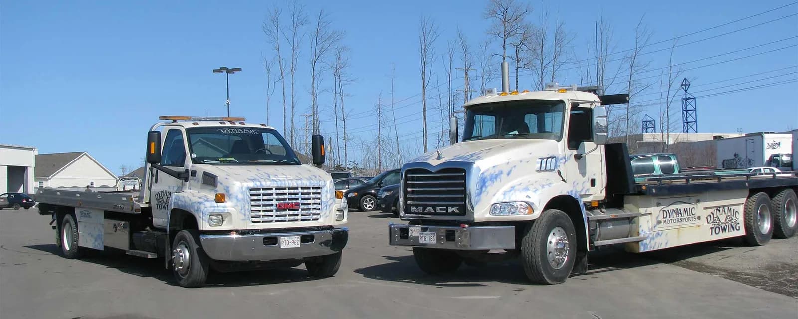 Deux plateformes de Dynamic Towing côte à côte dans la cour de Moncton — un GMC et un Mack