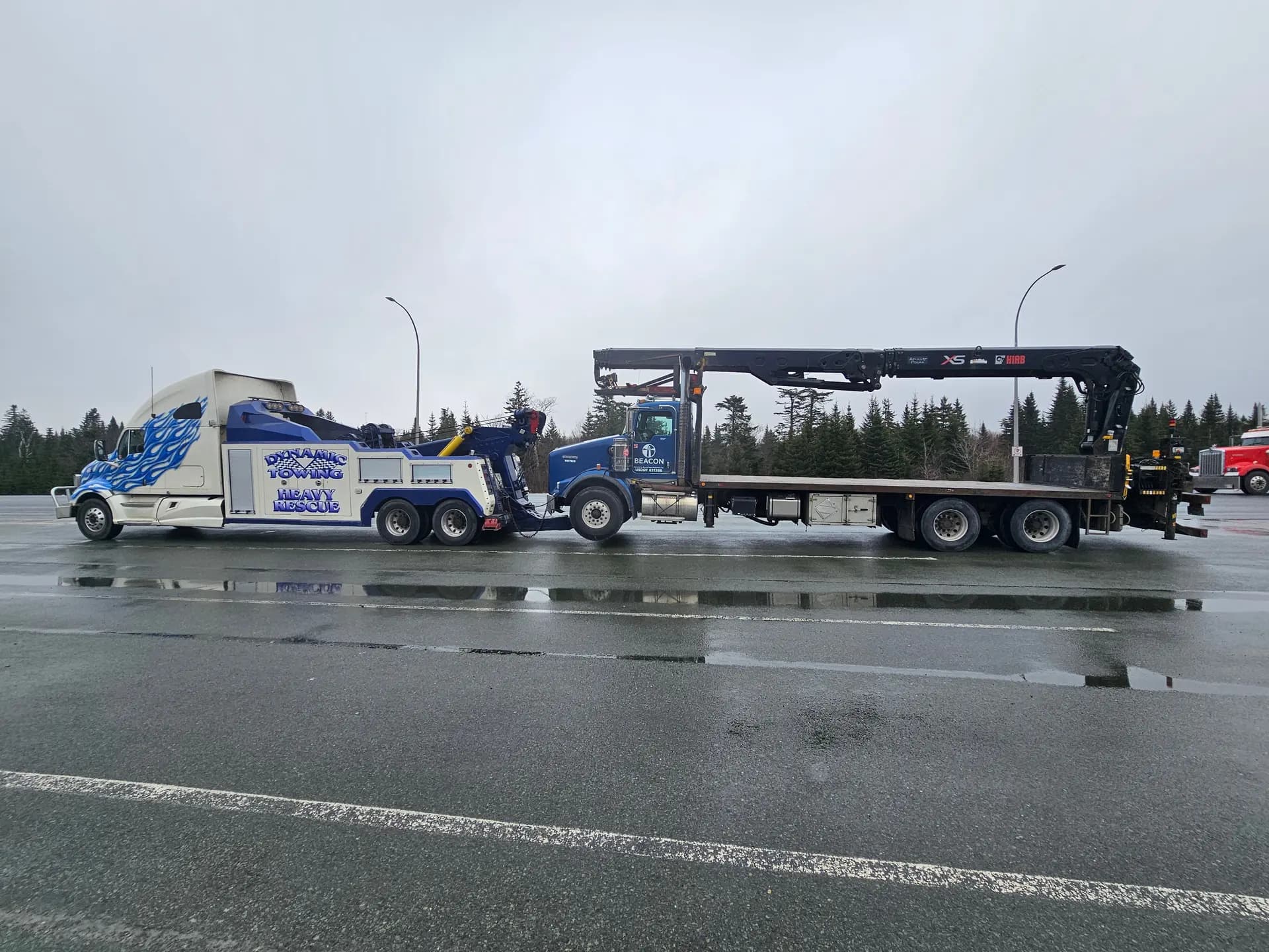 Dynamic Towing heavy wrecker towing a flat-deck crane truck